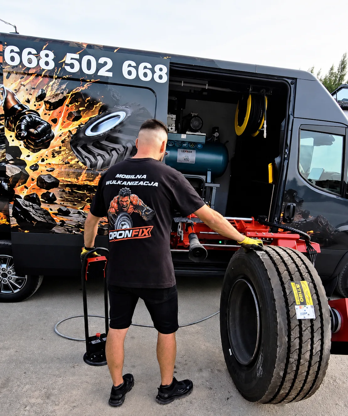 Mechanik OPONFIX toczy oponę ciężarową przy pojeździe